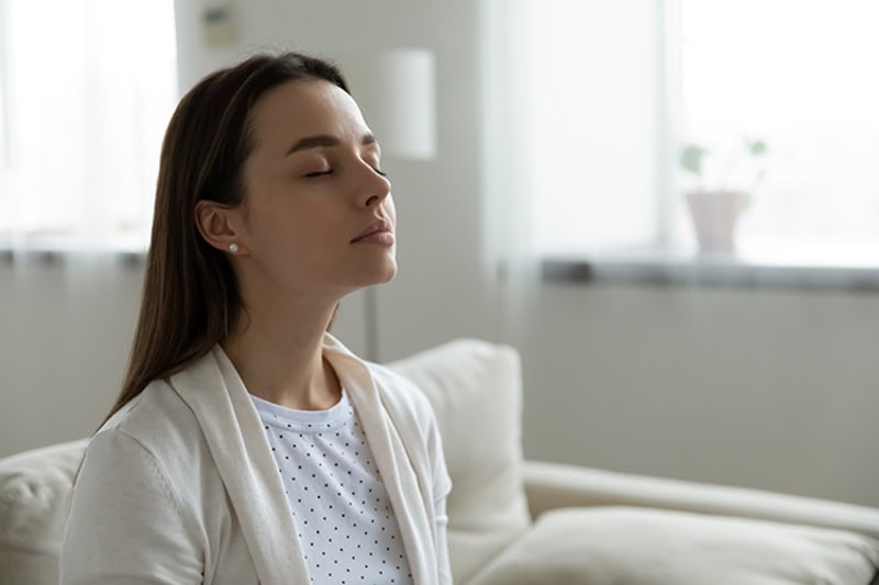 Why Do I Need a Humidifier? A woman breathing in clean air.
